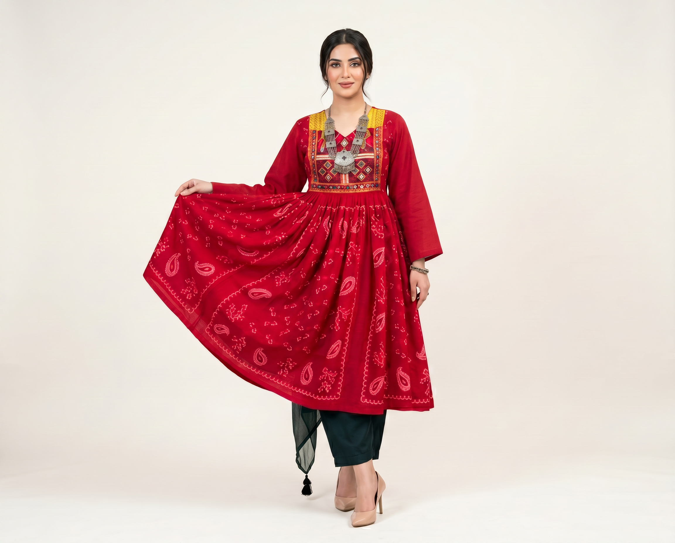 Model wearing a red Afghan dress with an embroidered shawl
